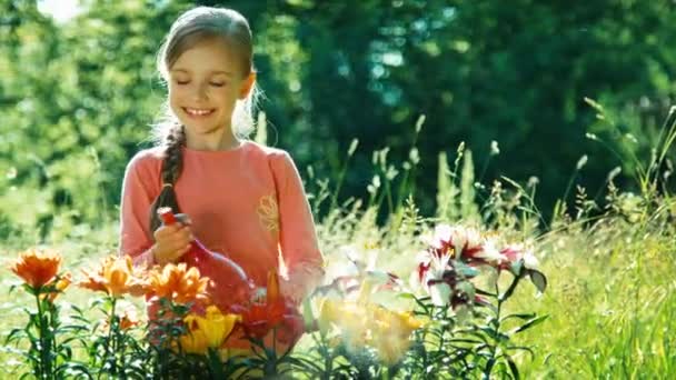 Menina retrato aspersão suas flores no jardim. Polegar para cima. Está bem. — Vídeo de Stock