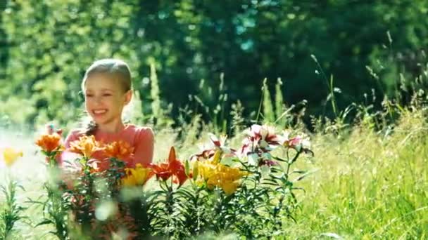 Mädchen streut Blumen im Garten — Stockvideo