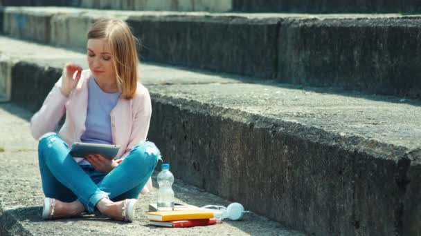 Krásná studentka pomocí počítače tablet pc a usmívající se zuby na kameru — Stock video