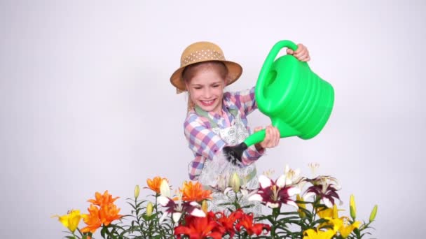 Slow motion portrait portrait flower-girl using watering can and sprinkling flowers and smiling with teeth. Taken from SonyA6300 — Stock Video