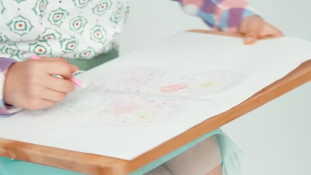Extreme close-up portret kind meisje in de hoed zit en vlinder puttend uit tekentafel — Stockvideo