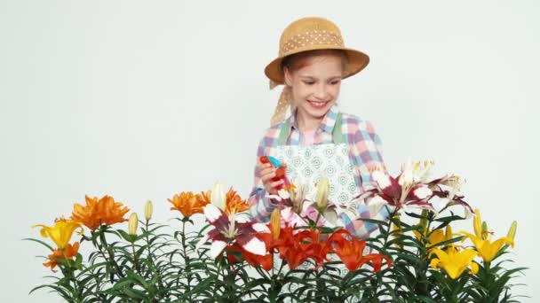 Flower-girl en sombrero rociando flores en la cámara y sonriendo con dientes sobre fondo blanco. Pulgar hacia arriba. Ok. — Vídeos de Stock