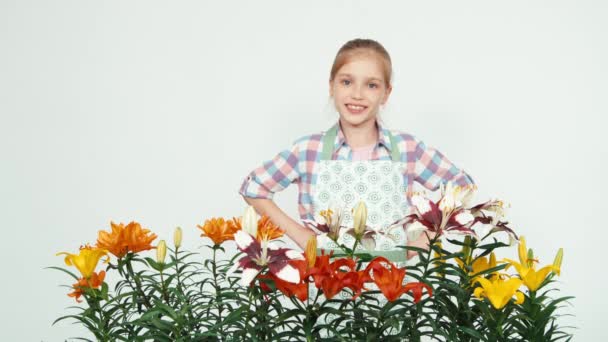 Närbild porträtt blomma-tjej ler mot kameran på vit bakgrund. Tummen upp. Okej — Stockvideo