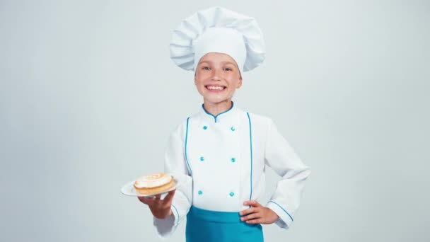 Piatto da forno con un po 'di torta alla panna e te lo dà. Chef 7-8 anni sorridente alla macchina fotografica. Isolato su sfondo bianco — Video Stock