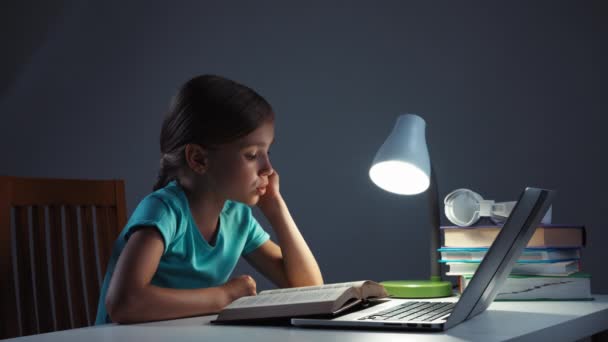 7-8 Jahre altes Mädchen liest in der Nacht Lehrbuch auf ihrem Schreibtisch — Stockvideo