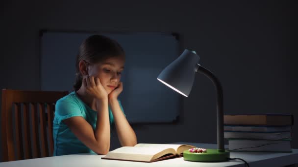 Niño leyendo un libro en la noche — Vídeos de Stock