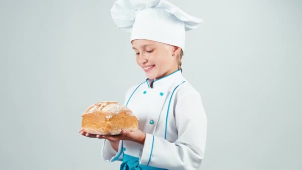 Close up portrait baker holds bread in her hands and gives you and smiling at camera isolated on white background — Stock Video