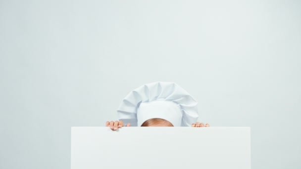 Close-up portret chef-kok achter het whiteboard en lachend op camera met tanden. Geïsoleerd op wit — Stockvideo