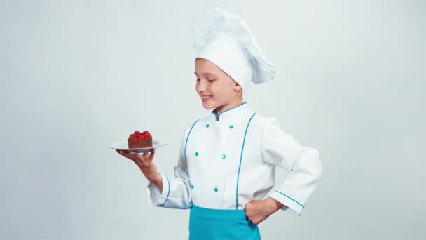 Portré fiatal baker közelről csokoládé torta málna tartja, és megadja azt. Szakács kamera mosolyogva. Elszigetelt fehér background — Stock videók