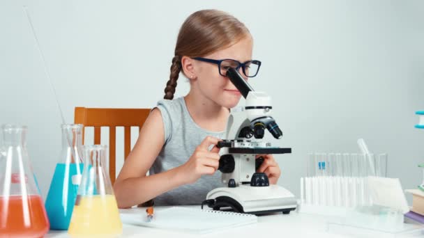 Four-eyes intenta usar un microscopio y sonreír — Vídeo de stock