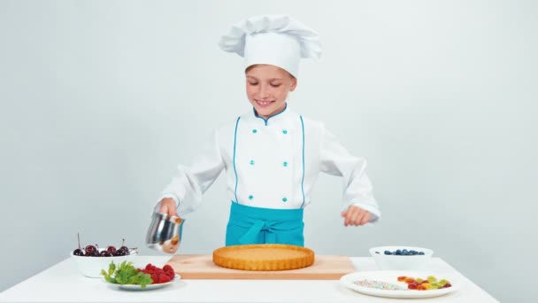 Girl pouring chocolate on cake. Young chef cook preparing a cake — Stock Video