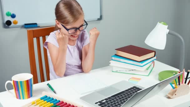 Gelukkig schoolmeisje en ongelukkig. Kind 7-8 jaar iets typen in laptop — Stockvideo