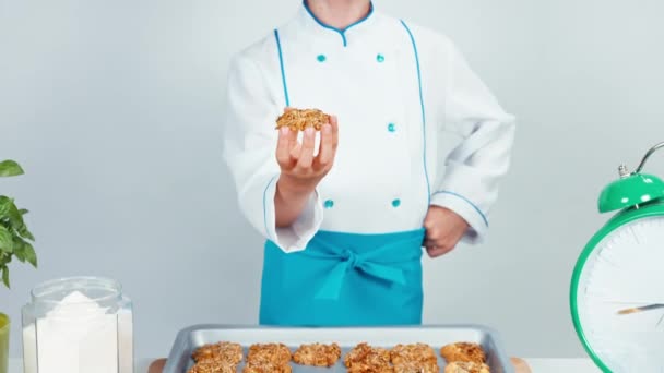Pequeña cocinera niña niño 7-8 años olfateando galletas y sonriendo a la cámara — Vídeo de stock