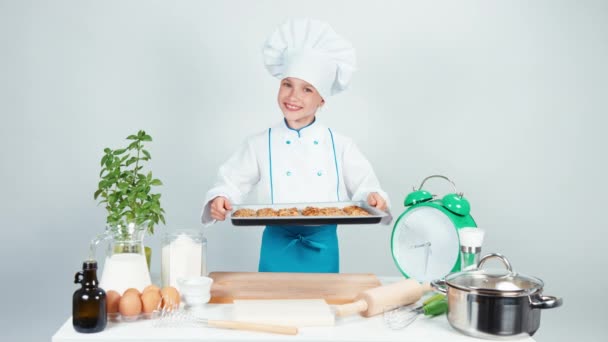 Little chef kok bedrijf oven-tray met koekje — Stockvideo