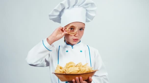 Kleine chef-kok houdt bord pasta staande op witte achtergrond camera kijken. Duimen omhoog. OK — Stockvideo