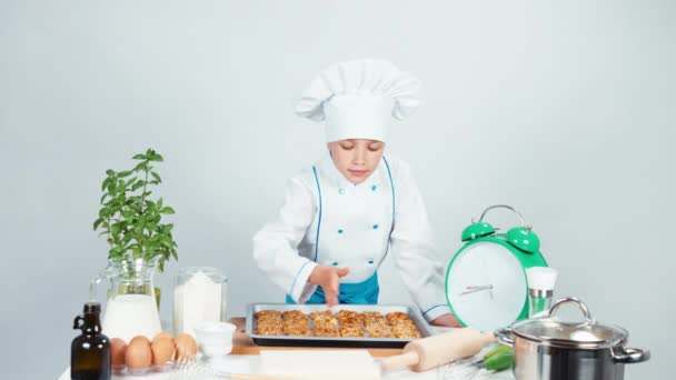 Portrait chef cook girl child 7-8 years old sniffing biscuits and smiling at camera. Isolated on white — Stock Video