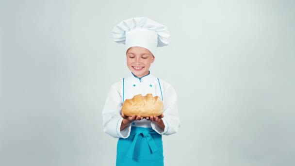 Portré baker vekni kenyeret fehér tart a kezében, és ad ön, és mosolyogva kamera elszigetelt fehér background — Stock videók