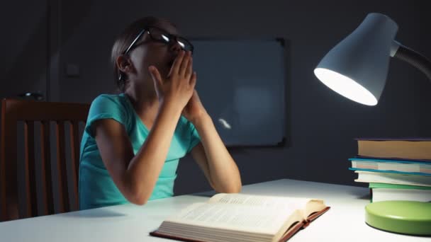 Retrato niña 7-8 años de edad en gafas leyendo un libro en la noche y se duerme — Vídeos de Stock