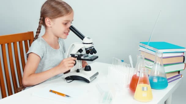 Ritratto ragazza con microscopio e scrittura nel taccuino e sorridente alla macchina fotografica con i denti — Video Stock