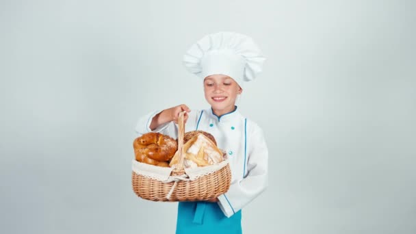 세로 작은 베이커는 빵과 미소를 카메라 흰색 배경에 고립의 바구니를 보유 하 고 — 비디오