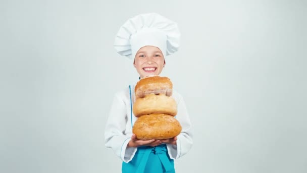 Portret małego baker posiada pieczywo w jej ręce i uśmiecha się do kamery na białym tle — Wideo stockowe