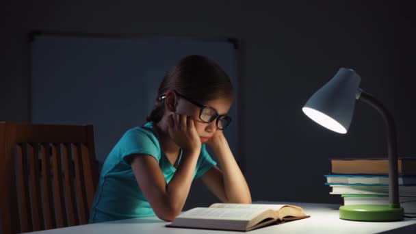 纵向配置文件儿童女孩戴眼镜在晚上看书 — 图库视频影像