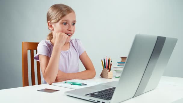 Retrato estudiante niña 7-8 años mirando con ojos grandes en el ordenador portátil. El niño tiene sorpresa. Pulgares arriba. Ok. — Vídeos de Stock