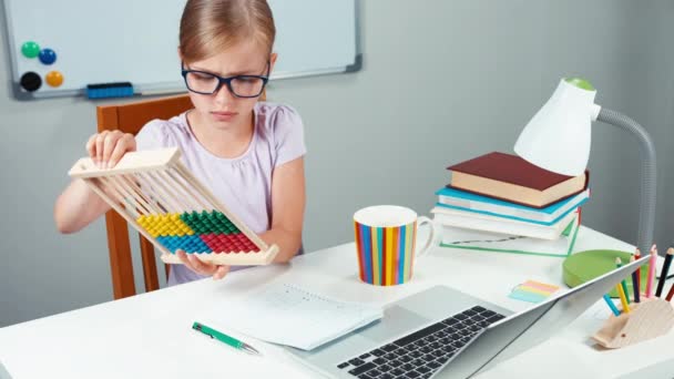 Retrato estudiante niña 7-8 años usando ábaco en su escritorio en casa — Vídeos de Stock