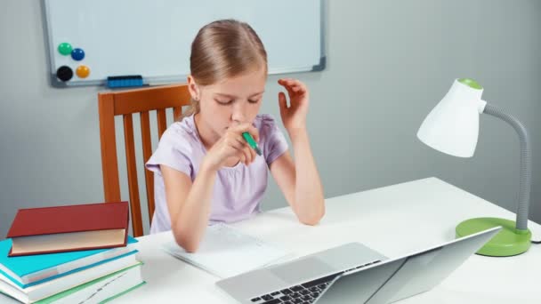 Ritratto studente ragazza 7-8 anni scrivendo nel suo taccuino e qualcosa digitando nel computer portatile — Video Stock