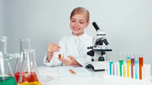 Portrait young chemist school girl holding test tube and looking at camera — Stock Video