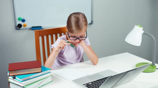 Estudante 7-8 anos algo escrevendo em seu caderno em sua mesa — Vídeo de Stock