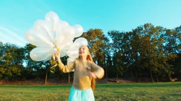 Blonde fille 8-9 ans courir à la caméra et tient ses ballons blancs — Video