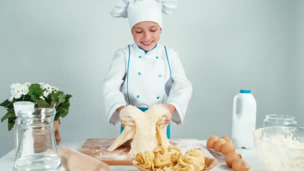 Unga bagare tjej att göra degen på köksbordet — Stockvideo