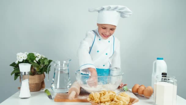 Jeune boulanger jouant avec la farine au bol à la table de la cuisine et souriant à la caméra — Video