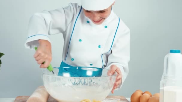 Young chef cook girl making dough using kitchen whisk — Stock Video