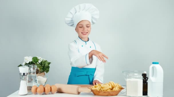 Baker tjej innehar brödkavel i köket ler mot kameran isolerad på vit — Stockvideo