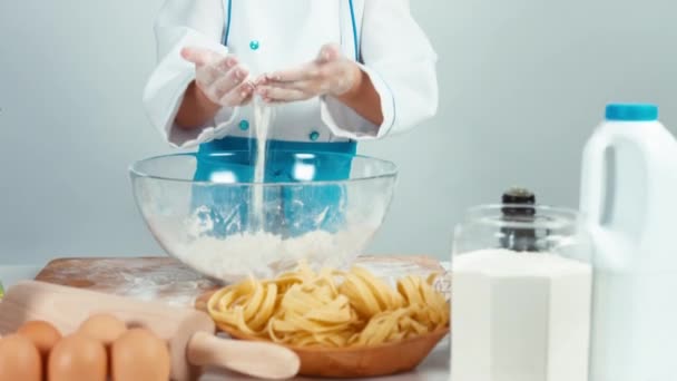 Retrato lindo cocinero sonriente chica jugando con harina y de pie en la mesa de la cocina — Vídeos de Stock