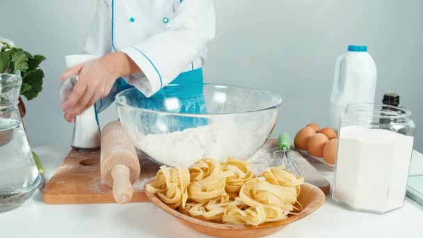 Händerna på unga bagare använder saltkar och mjöl vid köksbordet — Stockvideo