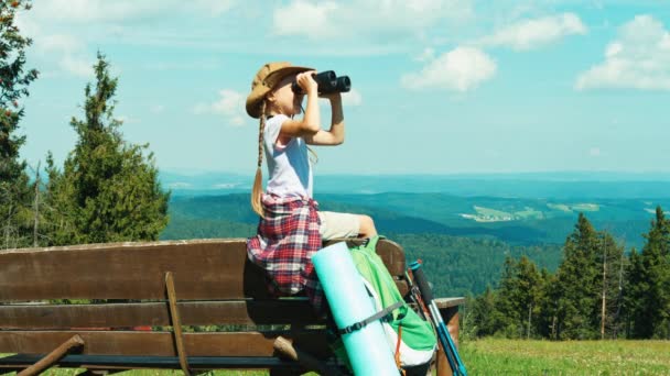 Turista de retratos usando prismáticos contra las montañas y riendo — Vídeos de Stock