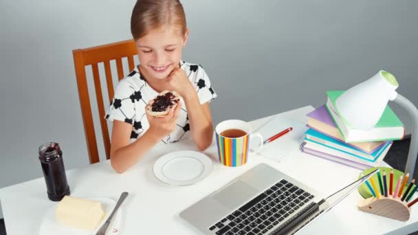 Ritratto ridere ragazza 7-8 anni tiene pane sandwich con burro marmellata seduto al tavolo isolato su bianco. Pollice in alto. Ok, vista dall'alto — Video Stock