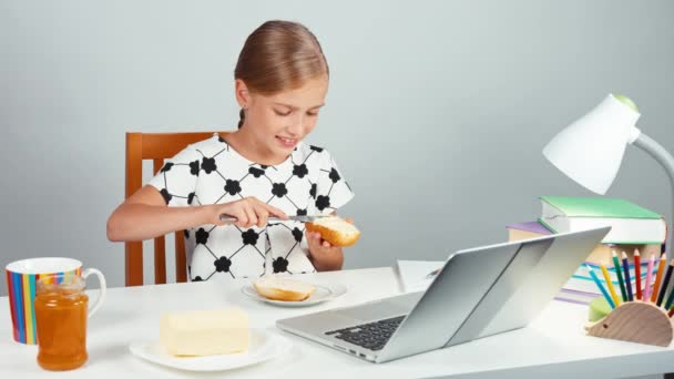 Stående skola flicka 7-8 år att göra smörgås med smör — Stockvideo