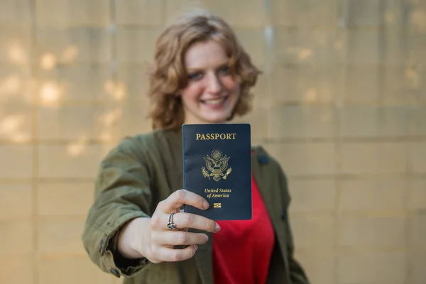 Chica sonriente sosteniendo pasaporte —  Fotos de Stock