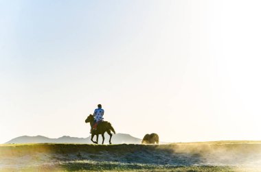 Anahat çoban ve derin sonbahar/fotoğraf Moğol plat batımında at