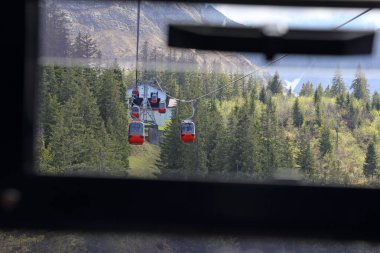Bir teleferik insanları bir dağın tepesine bir aşağıya taşır..