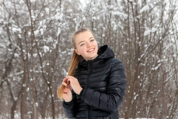 Retrato de invierno de una linda mujer joven en el parque de nieve —  Fotos de Stock