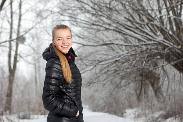 Retrato de invierno de una linda mujer joven en el parque de nieve —  Fotos de Stock