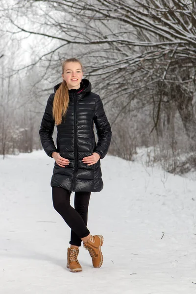 Retrato de invierno de una linda mujer joven en el parque de nieve —  Fotos de Stock