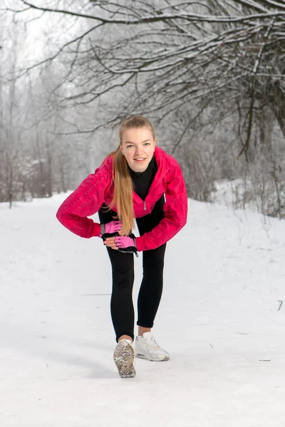 Mujer joven haciendo ejercicios de estiramiento en invierno —  Fotos de Stock