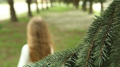 Kız atlamalı ve ishal düz çizgiler Park çam ağaçlarının arasında kamera uzak