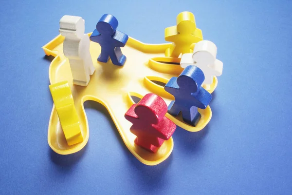 Plastic Hand with Wooden Figures — Stock Photo, Image
